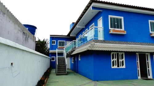 TamoiosNacif&Alcantara Suítes的蓝色的房子,旁边设有楼梯