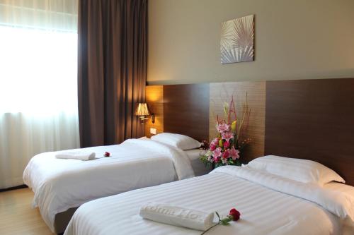 巴特沃思芬芳酒店的两张位于酒店客房的床,上面有鲜花