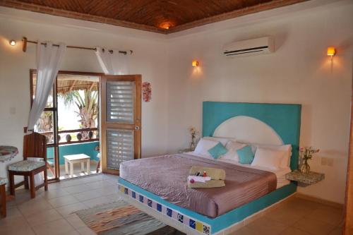 玛哈威Nacional Beach Club & Bungalows的一间带大床的卧室和一个阳台