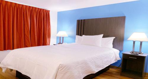 尼亚加拉瀑布SureStay Plus Hotel by Best Western Niagara Falls East的一间卧室配有一张带两盏灯的大型白色床。