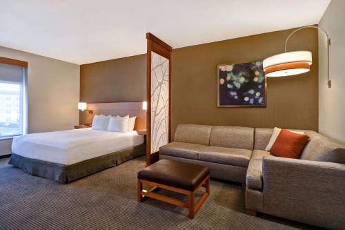 亨茨维尔Hyatt Place Huntsville - Research Park - Redstone的酒店客房,配有床和沙发