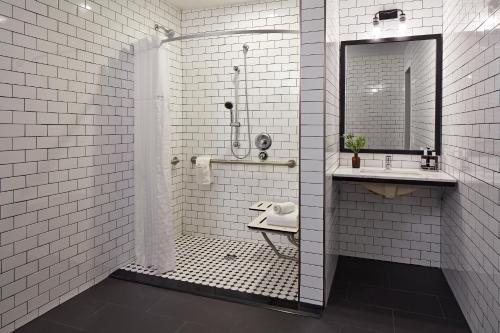 圣地亚哥浪琴旅馆的带淋浴和盥洗盆的白色瓷砖浴室