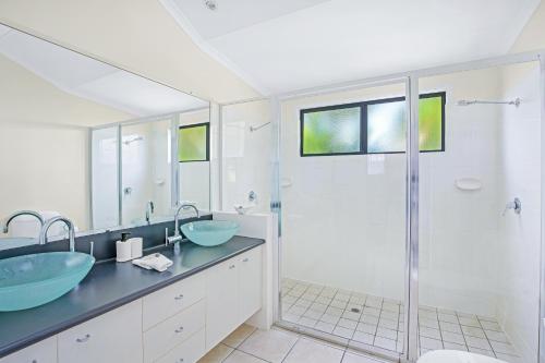 帝坎湾Tin Can Bay Marina Villas的一间带两个盥洗盆和淋浴的浴室