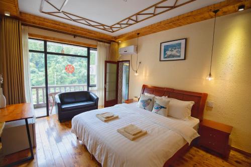 德清莫干山竹景山庄的一间卧室配有一张带椅子的床和一扇窗户
