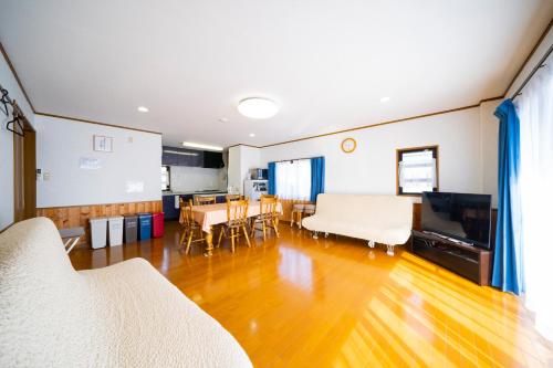 MitsuneHachijyo-island Blue Eight -八丈島ブルーエイト-的一间铺有木地板的客厅和一间餐厅