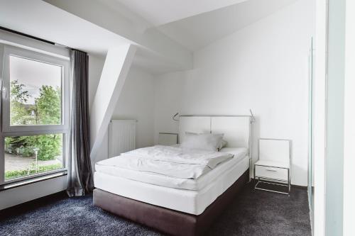 科隆&REPEAT Köln Airport的白色的卧室设有床和窗户