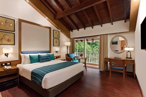 布莱尔港Welcomhotel by ITC Hotels, Bay Island, Port Blair的一间卧室配有一张床、一张书桌和一个窗户。