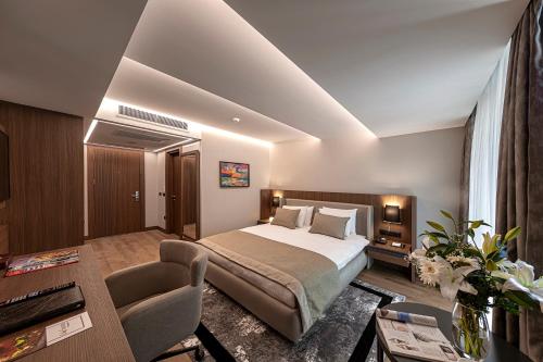 伊斯坦布尔Vital Hotel Fulya Istanbul Sisli的酒店客房配有一张床铺和一张桌子。