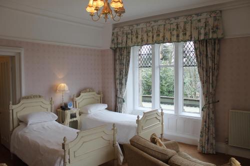 宾格利奥克伍德大厅酒店的一间卧室设有两张床和窗户。