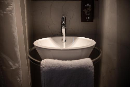塞萨洛尼基Domotel Olympia的浴室水槽配有水龙头和毛巾