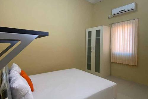 沙马林达KoolKost Syariah near Gedung DPRD Prov. KalTim的卧室配有白色的床和窗户。