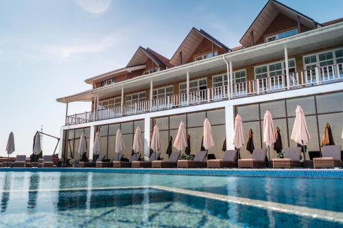 Kam”yani PotokyСпа-Готель Потоки Хауз的酒店设有带椅子和遮阳伞的游泳池