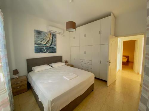 法罗斯岛Sifneiko Arxontiko的卧室配有一张白色大床