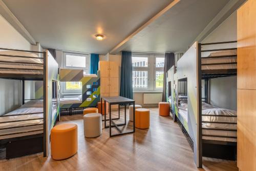 汉堡汉堡火车总站酒店的宿舍间设有双层床和桌椅。