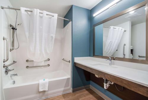 米尔堡WoodSpring Suites Fort Mill的带浴缸、水槽和镜子的浴室