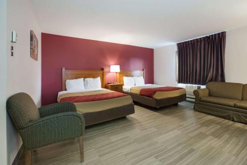 埃斯卡诺巴Econo Lodge Inn & Suites的酒店客房,设有两张床和一张沙发