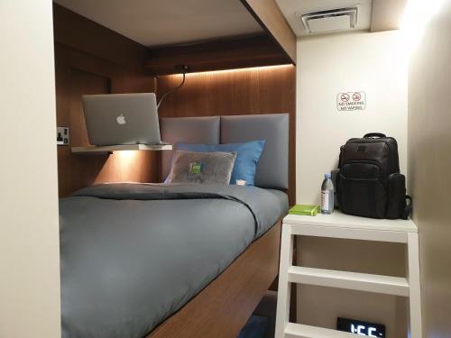 迪拜sleep 'n fly Sleep Lounge, C-Gates Terminal 3 - TRANSIT ONLY的一间卧室配有一张带笔记本电脑的床