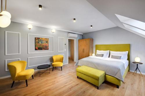波普拉德Kalix Boutique Hotel的一间卧室配有一张床和两张黄色椅子