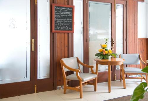 卡拉纳雅达卡拉拉提雅达旅馆的一张桌子,两把椅子和花瓶
