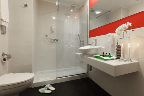 热那亚热那亚假日酒店的带淋浴、盥洗盆和卫生间的浴室