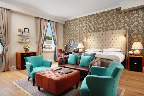 伦敦The Bailey's Hotel London Kensington的酒店客房配有一张床、一张沙发和椅子。