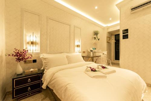 哥打京那巴鲁AJ Residence - Above Peppermint Asia City的一间卧室配有一张白色大床,床上有鲜花