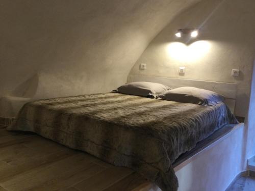 Castello-di-RostinoCasa LiLi的一张带两个枕头的床和墙上的灯