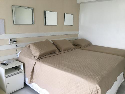 萨尔瓦多210平巴伊亚巴拉公寓的卧室配有一张床铺,墙上挂有两面镜子