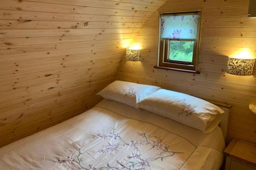 伍拉科姆Birdsong Lodge的小木屋内的一张床位,两盏灯