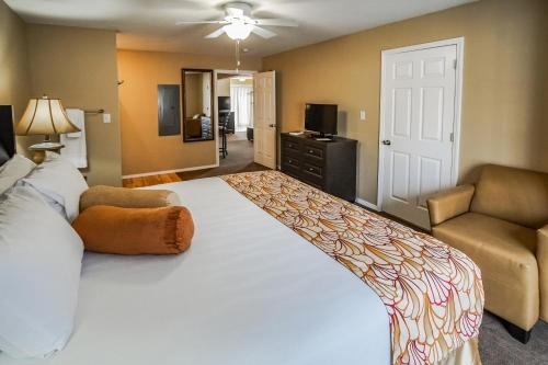 布兰森联排别墅度假村的卧室配有一张白色的大床和一张沙发。