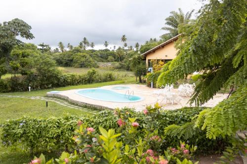 因巴塞Pousada Lagoa Da Pedra的一个带游泳池和房子的庭院