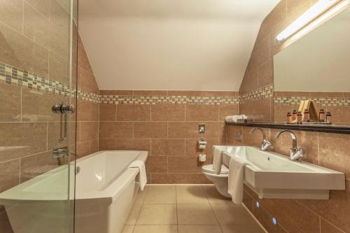 奥马银桦酒店的带浴缸和盥洗盆的浴室