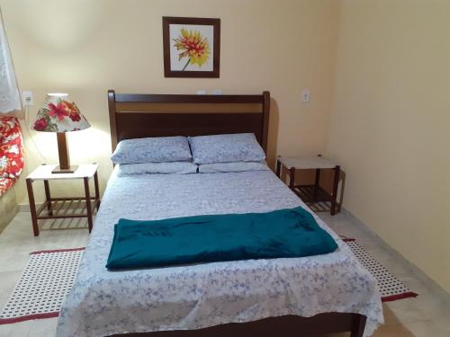佩尼多Casa Chalé em Penedo的一间卧室配有一张带蓝色床单的大床