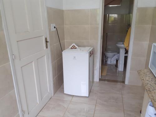 佩尼多Casa Chalé em Penedo的带卫生间的浴室内的小型白色冰箱