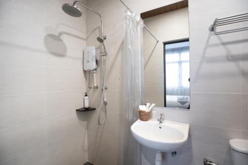乔治市乙街酒店的白色的浴室设有水槽和淋浴。