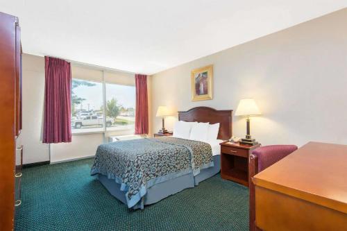 威奇托Blue Way Inn & Suites Wichita East的配有一张床和一张书桌的酒店客房