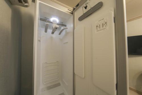 春川古德斯代格兰德春川汽车旅馆的浴室设有门和灯,配有淋浴