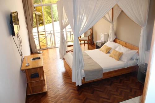 塔那那利佛里维埃拉花园酒店的一间卧室配有一张带蚊帐的床