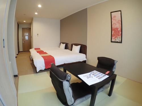 箱根田园箱根度假村的酒店客房,配有一张床、一张桌子和椅子