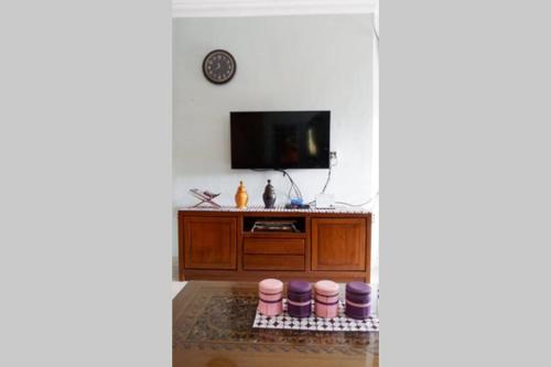 KedatonSamba Homestay的一间带电视和橱柜的客厅
