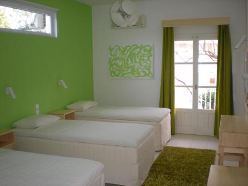 斯基亚索斯镇马诺利斯之家公寓式酒店的带三张床和窗户的客房