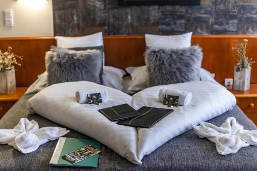玛特阿哈泽4 Évszak Hegyihotel的一张带白色枕头的床和书籍