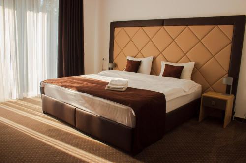 基希讷乌Bernardazzi Grand Hotel的一间卧室配有一张大床和大床头板