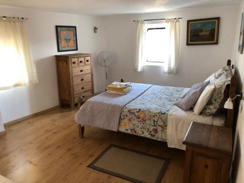 奥埃拉斯Typical small house near Lisbon的一间卧室配有一张床、一个梳妆台和一扇窗户。