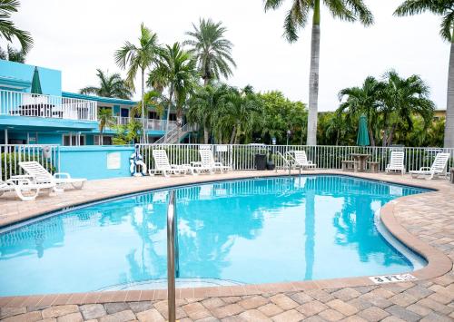 圣徒皮特海滩湾畔及滨海旅馆的一个带椅子和棕榈树的大型游泳池