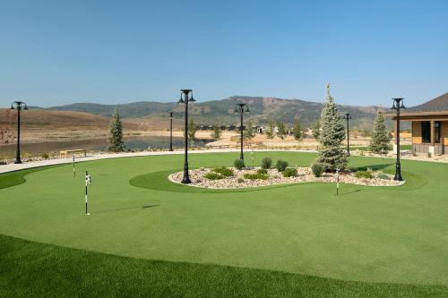 格兰比Sun Outdoors Rocky Mountains的绿色的高尔夫球场和高尔夫球手