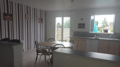 卢瓦尔河畔米德Gîte près de Chambord的厨房配有桌子和桌椅