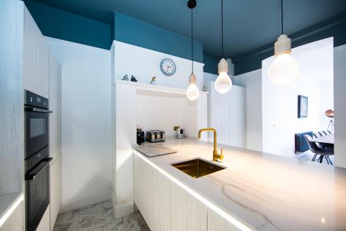 罗宾胡兹贝Rounton Villa by Maison Parfaite - Hot Tub - Sea Views - Parking的厨房设有蓝色的天花板、水槽和柜台。