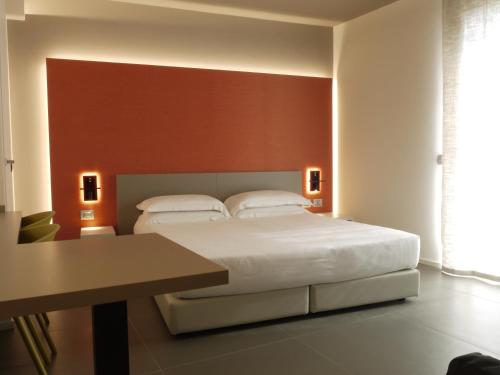 伊莫拉RB del Teatro&Apartaments的卧室配有一张白色的大床和一张桌子