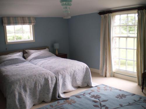 布里奇诺斯Duken Courtyard Cottage的一间卧室设有两张床和两个窗户。